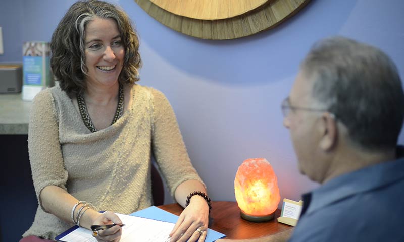 Acupuncturist across the table from a patient