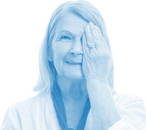 a senior woman with macular degeneration covering one eye as she takes her eye test